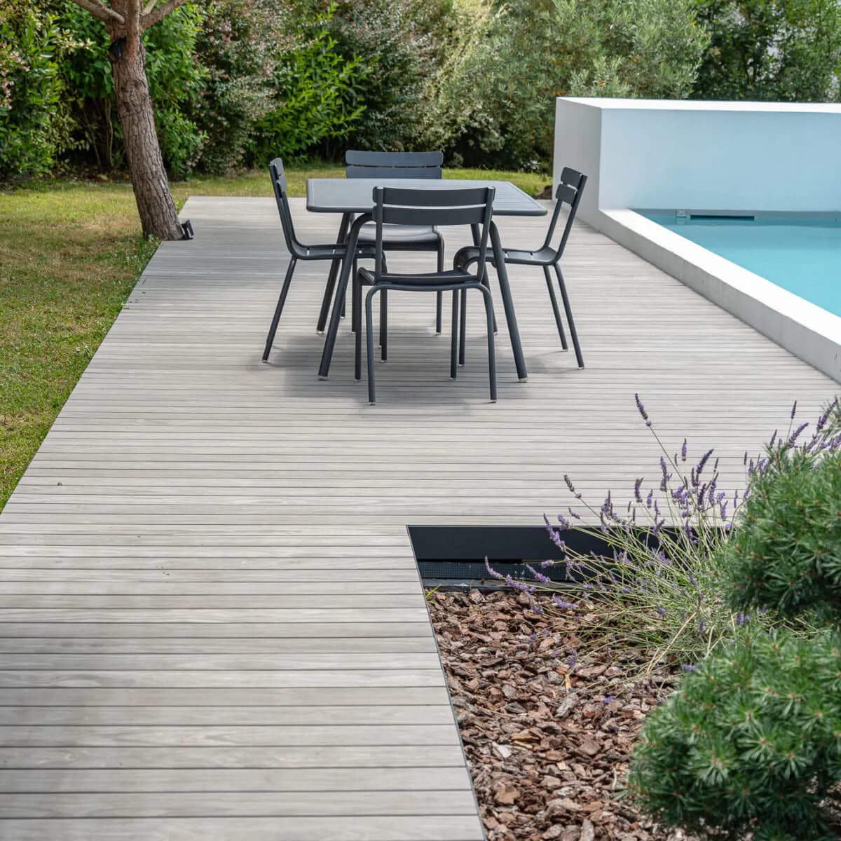 Coin repas sur terrasse Accoya Color Gris au bord d’une piscine