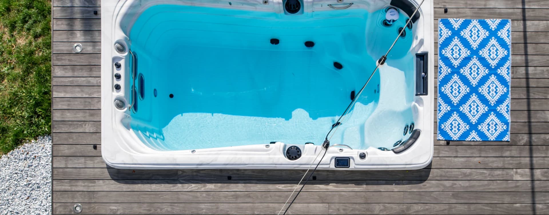 Vue aérienne d’un spa de nage encastré dans un deck en bois patiné gris argenté