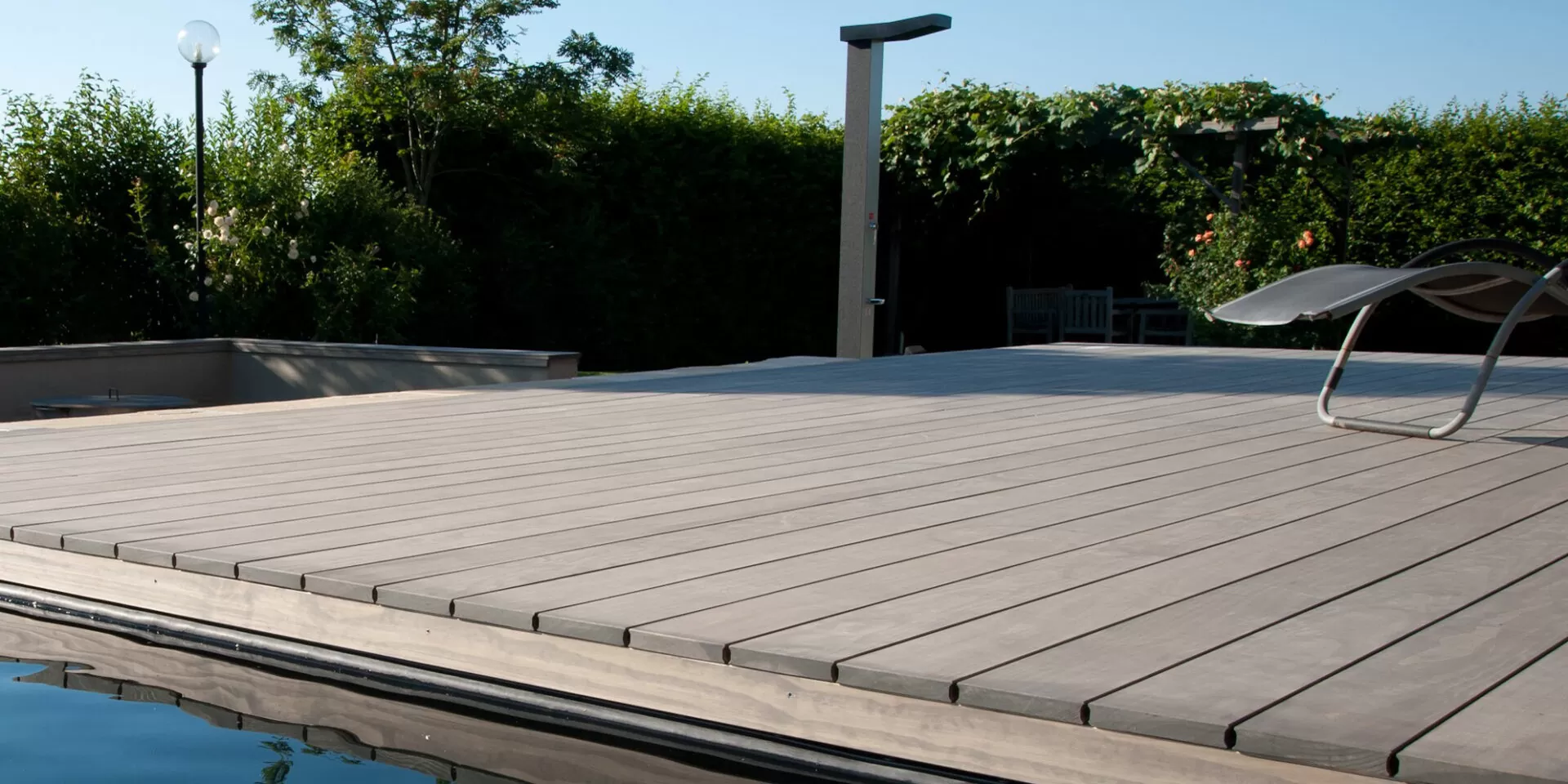 Terrasse de piscine en Accoya patiné gris argenté, en fin de journée